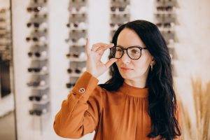 female-ophtalmologist-demonstrating-spectacles-optician-shop
